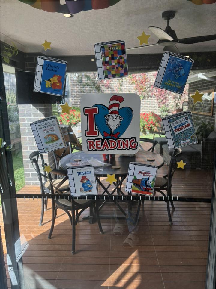 I Love Reading sign on a glass door surrounded by illustrated book cover stickers personalized for Tristan.