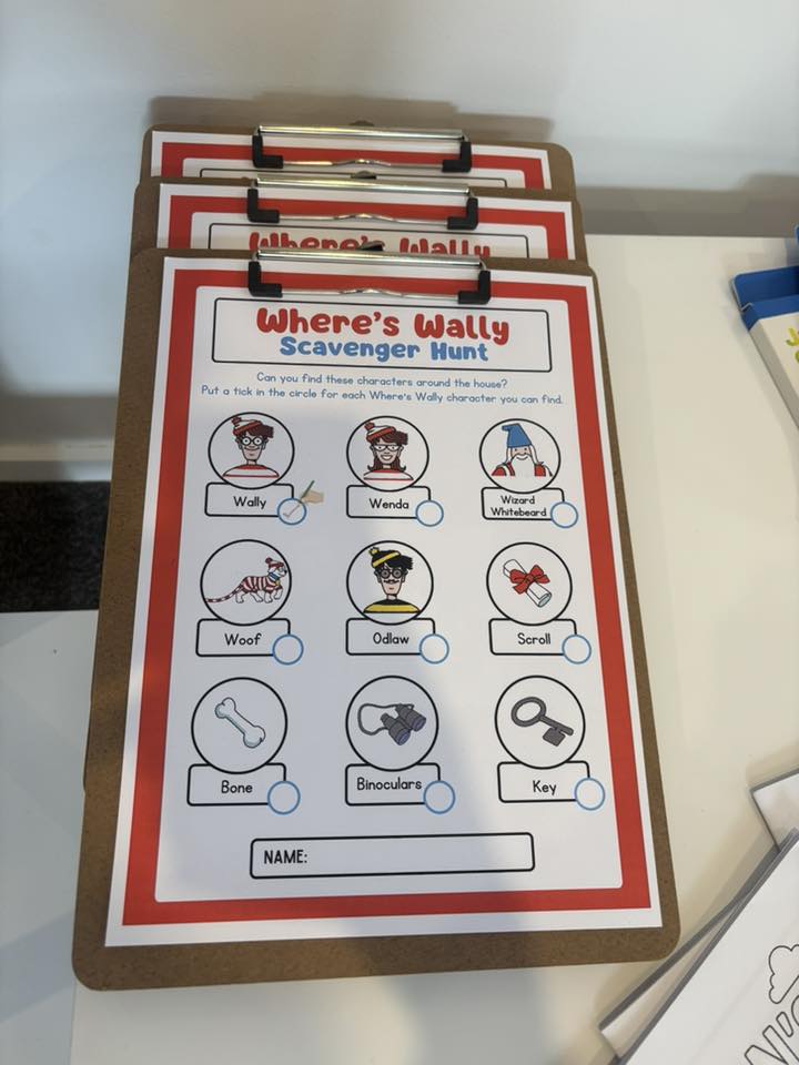 Printed Where's Wally activity sheets on clipboards for a home scavenger hunt.