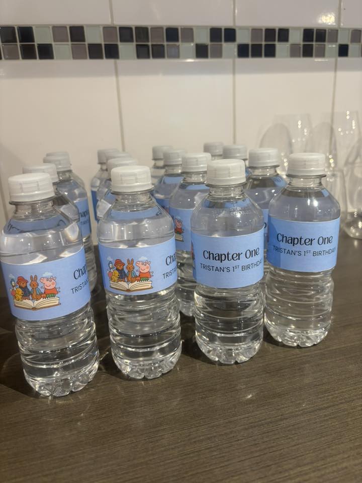 Group of water bottles with custom blue labels for Tristan's 1st birthday featuring Peppa Pig characters.