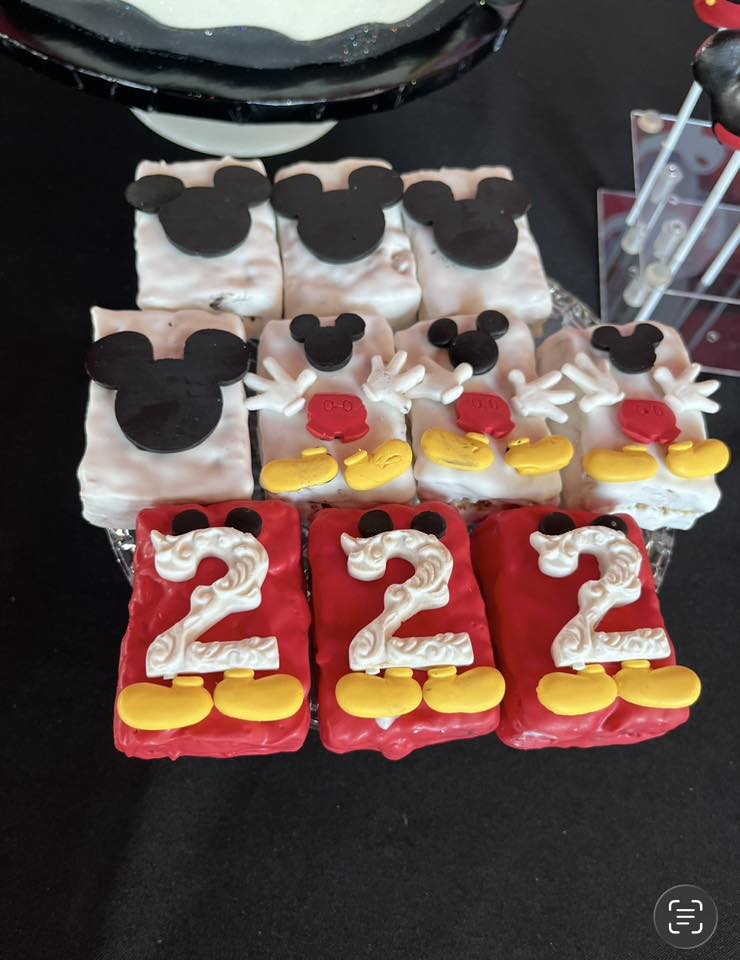 Mickey Mouse themed Rice Krispie treats decorated with fondant ears, red pants, yellow shoes, and white number twos.
