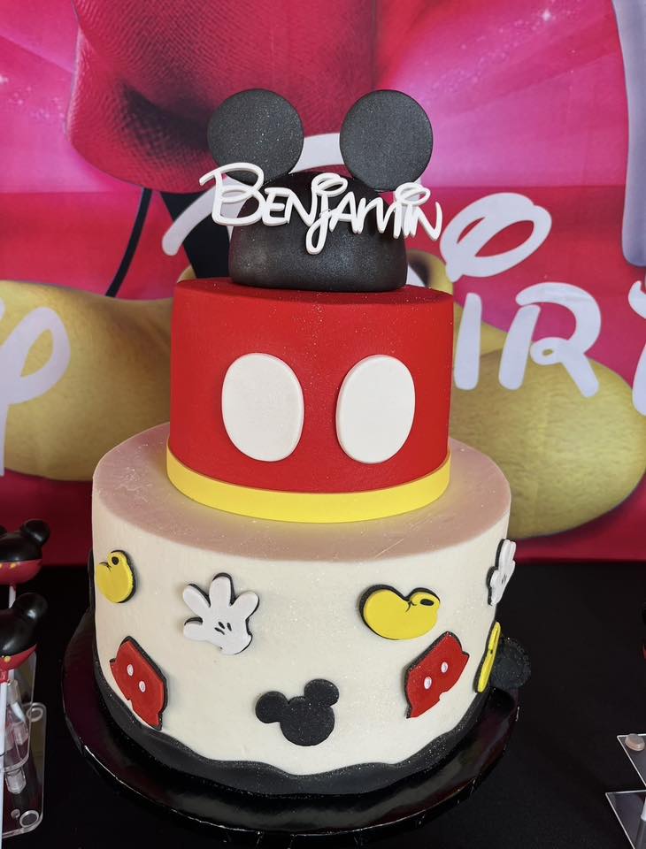 Two-tiered Mickey Mouse themed birthday cake with a personalized Benjamin topper.
