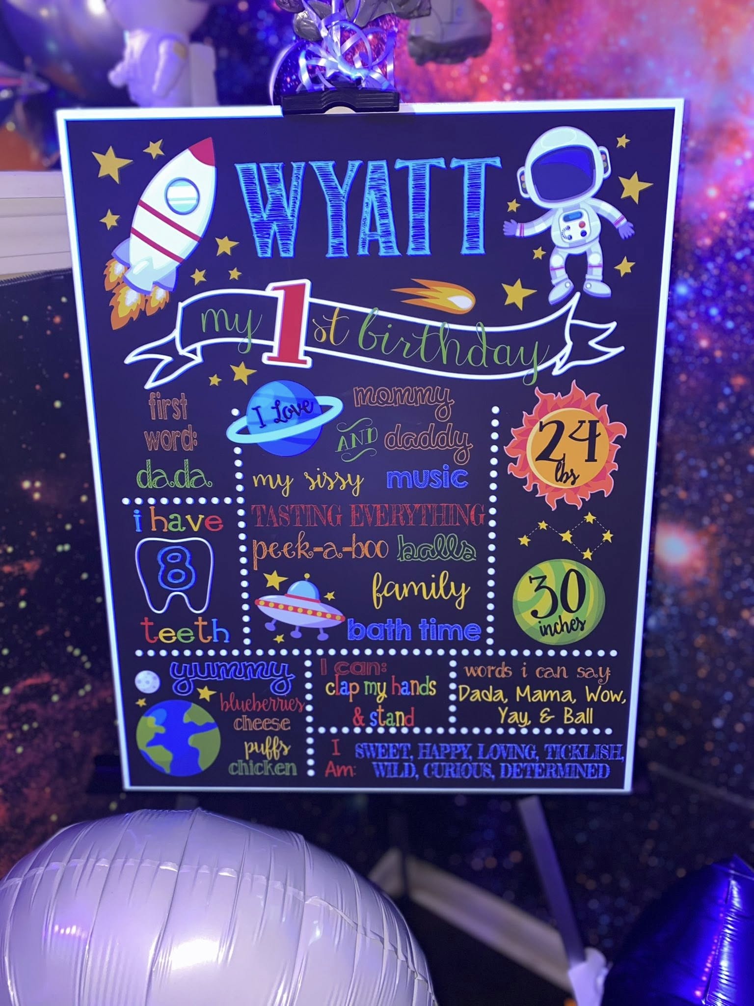 Space-themed chalkboard sign for Wyatt's first birthday detailing his current milestones and favorites.