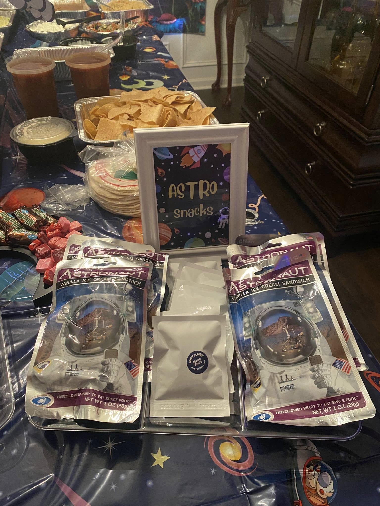 Astronaut brand freeze-dried vanilla ice cream sandwiches displayed on a space-themed snack table.