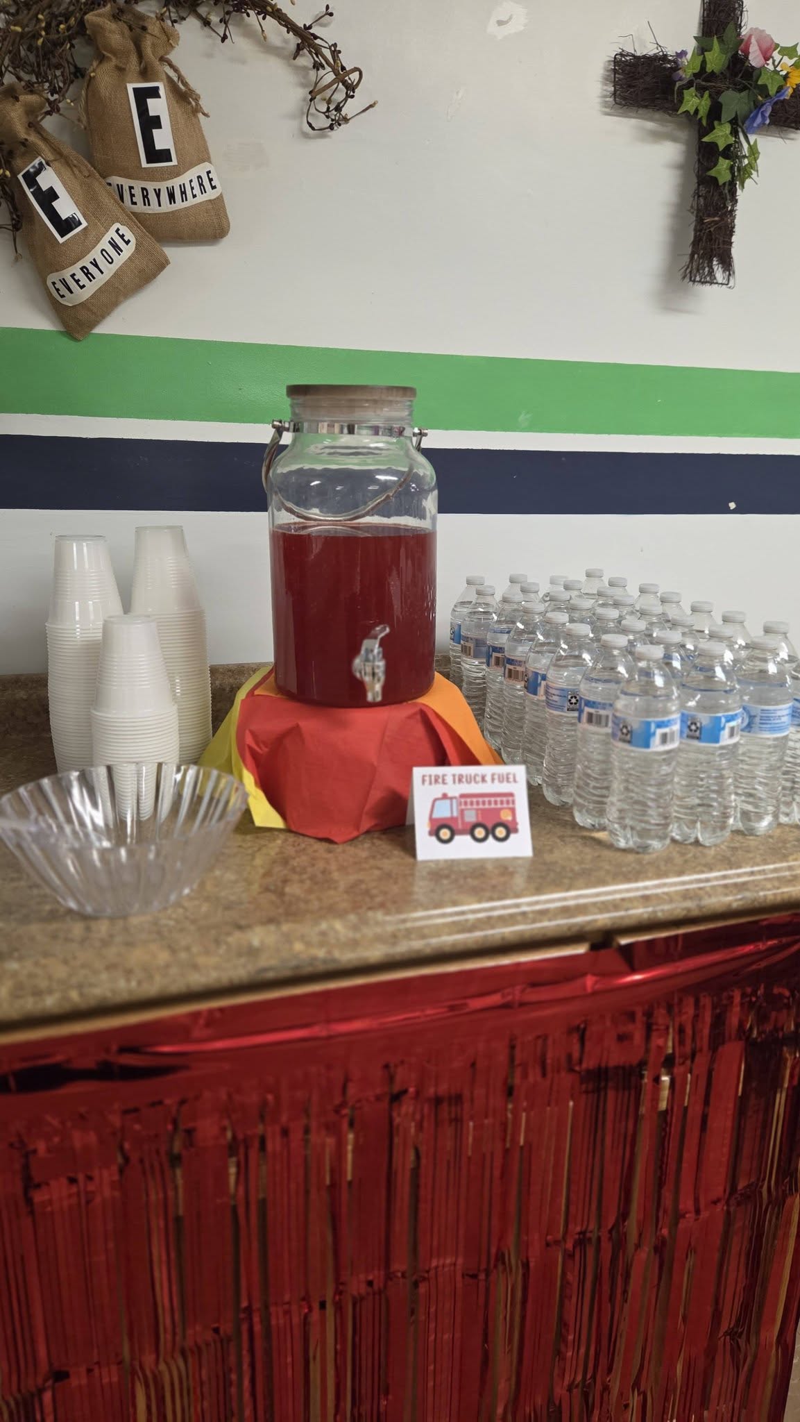 Beverage station decorated for a fire truck themed party with a large drink dispenser labeled Fire Truck Fuel.