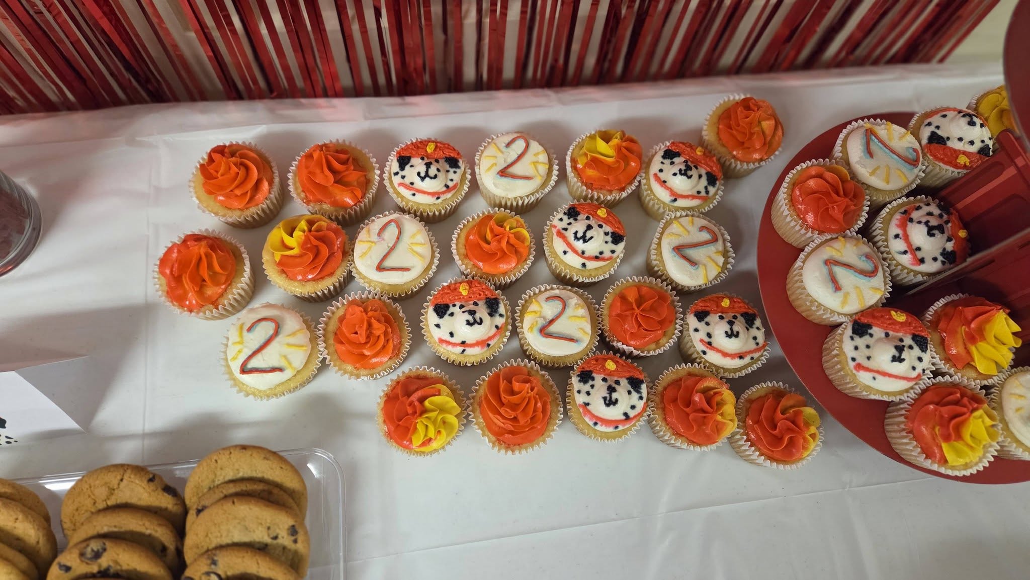 Assorted cupcakes decorated with dalmatian faces and the number two, arranged for a second birthday party.