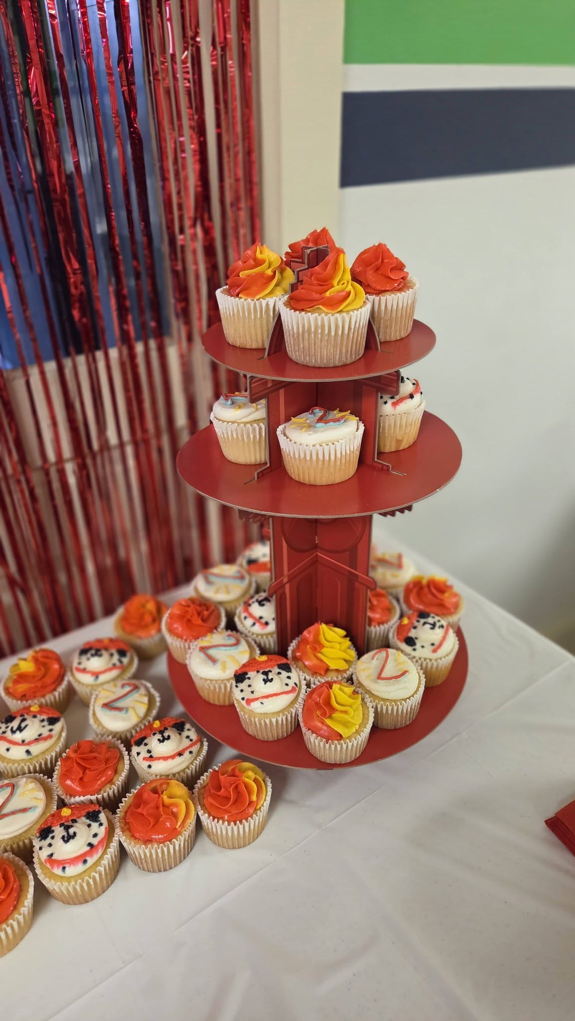 Tiered red cupcake stand featuring fire-themed frosting and dalmatian-adorned cupcakes for a 2nd birthday celebration