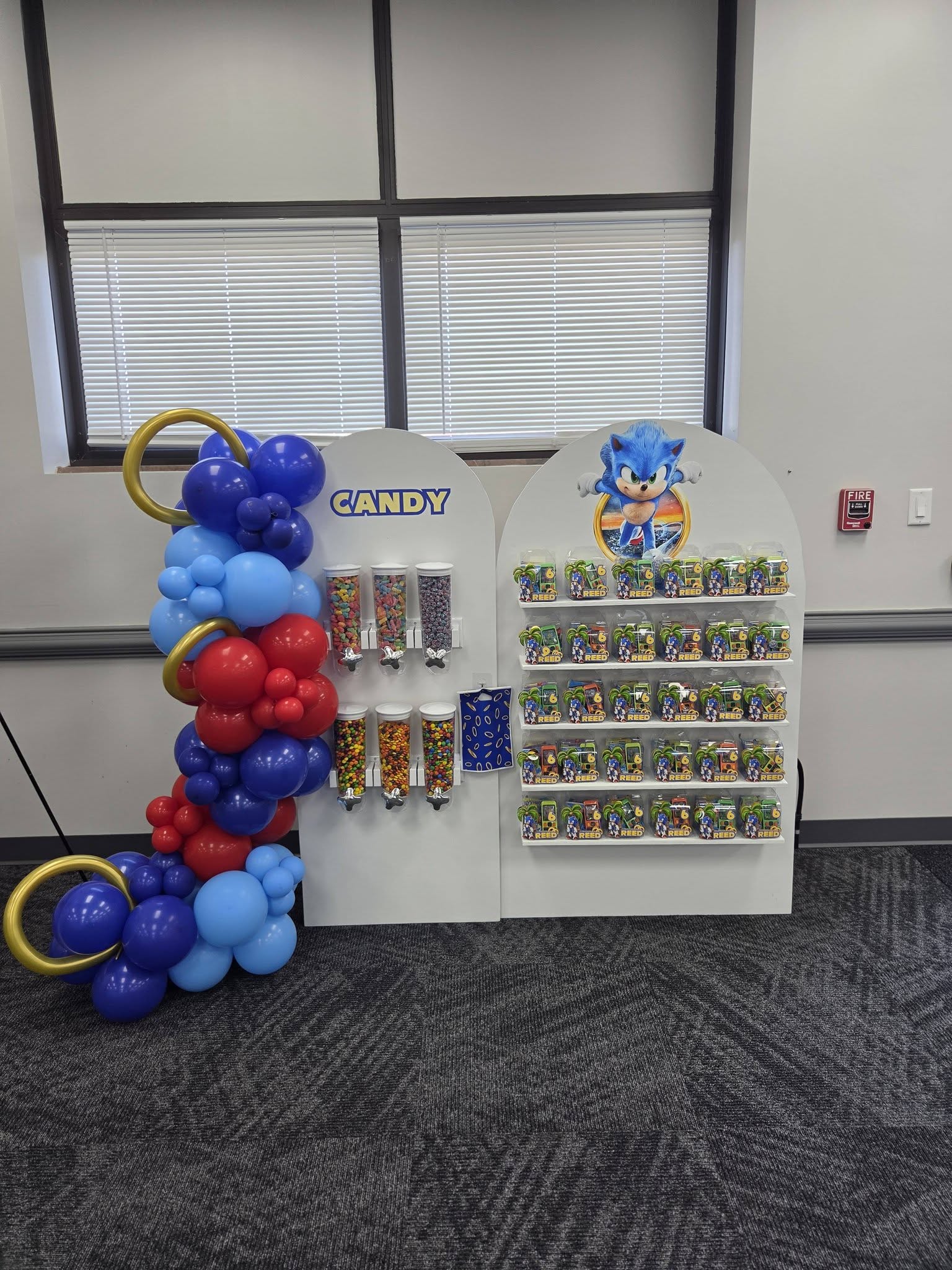 Sonic the Hedgehog themed party favor rack with candy dispensers and customized treats.