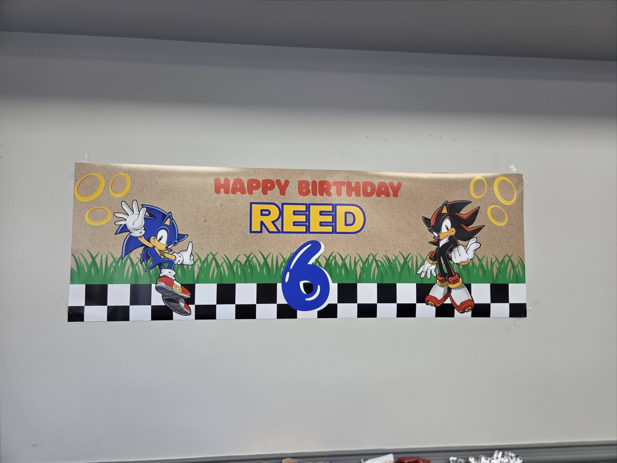 Custom Sonic the Hedgehog themed birthday banner that reads Happy Birthday Reed with a prominent blue number six.