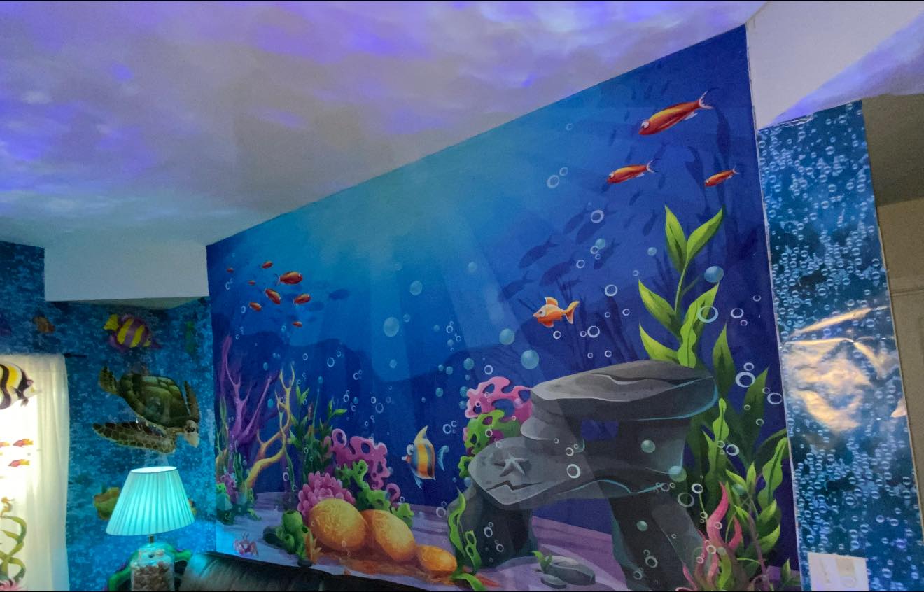 Colorful underwater ocean scene wall mural for a child's bedroom featuring coral, tropical fish, and a sea turtle.