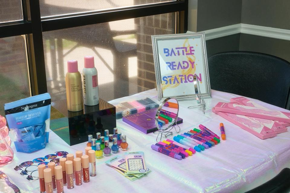 Battle Ready Station table with makeup, nail polish, hair accessories, and face gems.