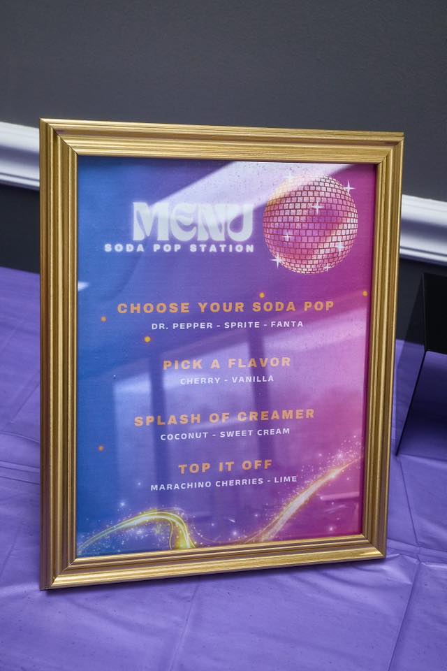 Soda Pop Station menu sign in a gold frame, listing soda, flavor, creamer, and topping choices.