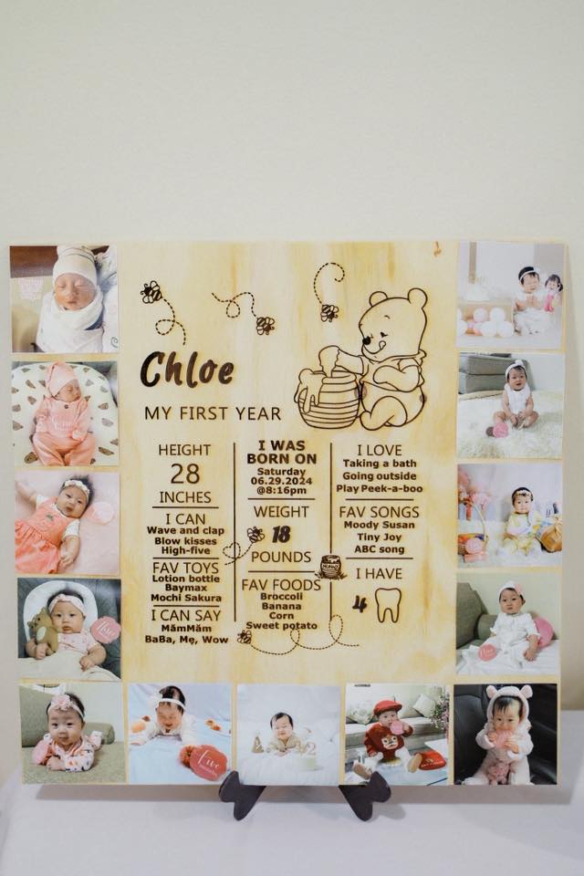 Personalized wooden baby first year milestone board featuring photos of a baby girl and Winnie the Pooh design.