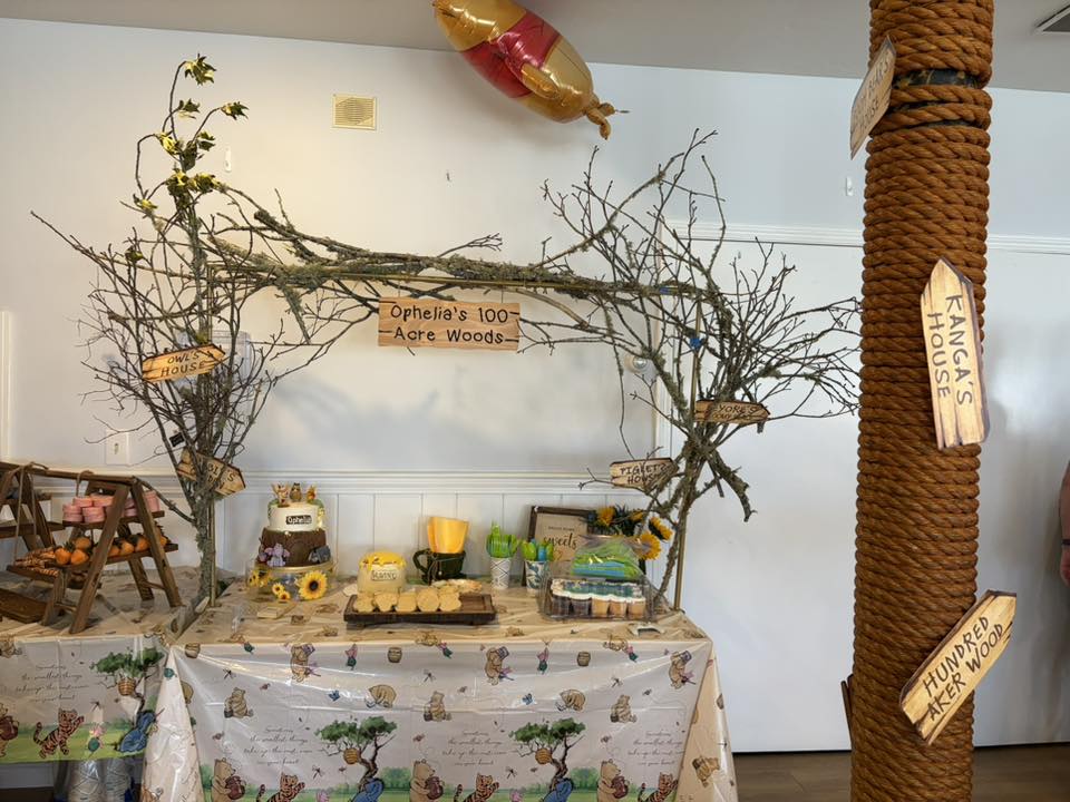 Winnie the Pooh themed dessert table with Hundred Acre Woods decor and directional signs