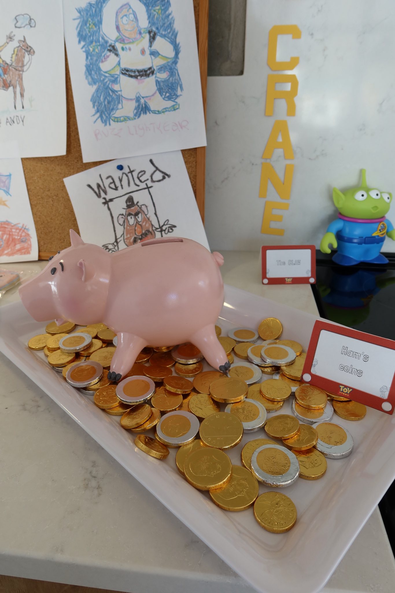 Toy Story Hamm piggy bank standing on a tray filled with gold and silver chocolate coins.