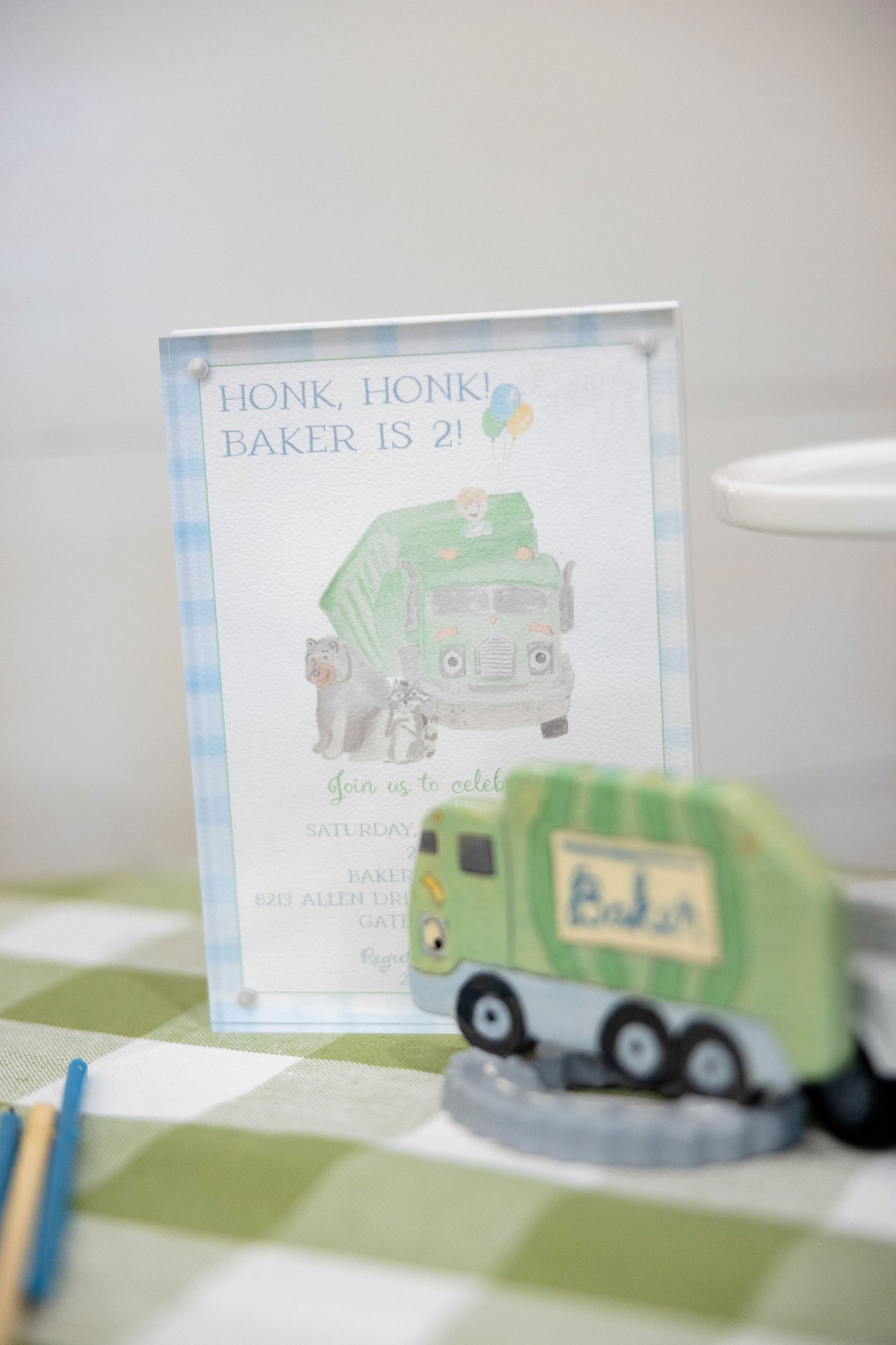Tabletop sign for a second birthday party featuring a cartoon garbage truck and animals with the text Honk Honk Baker Is 2