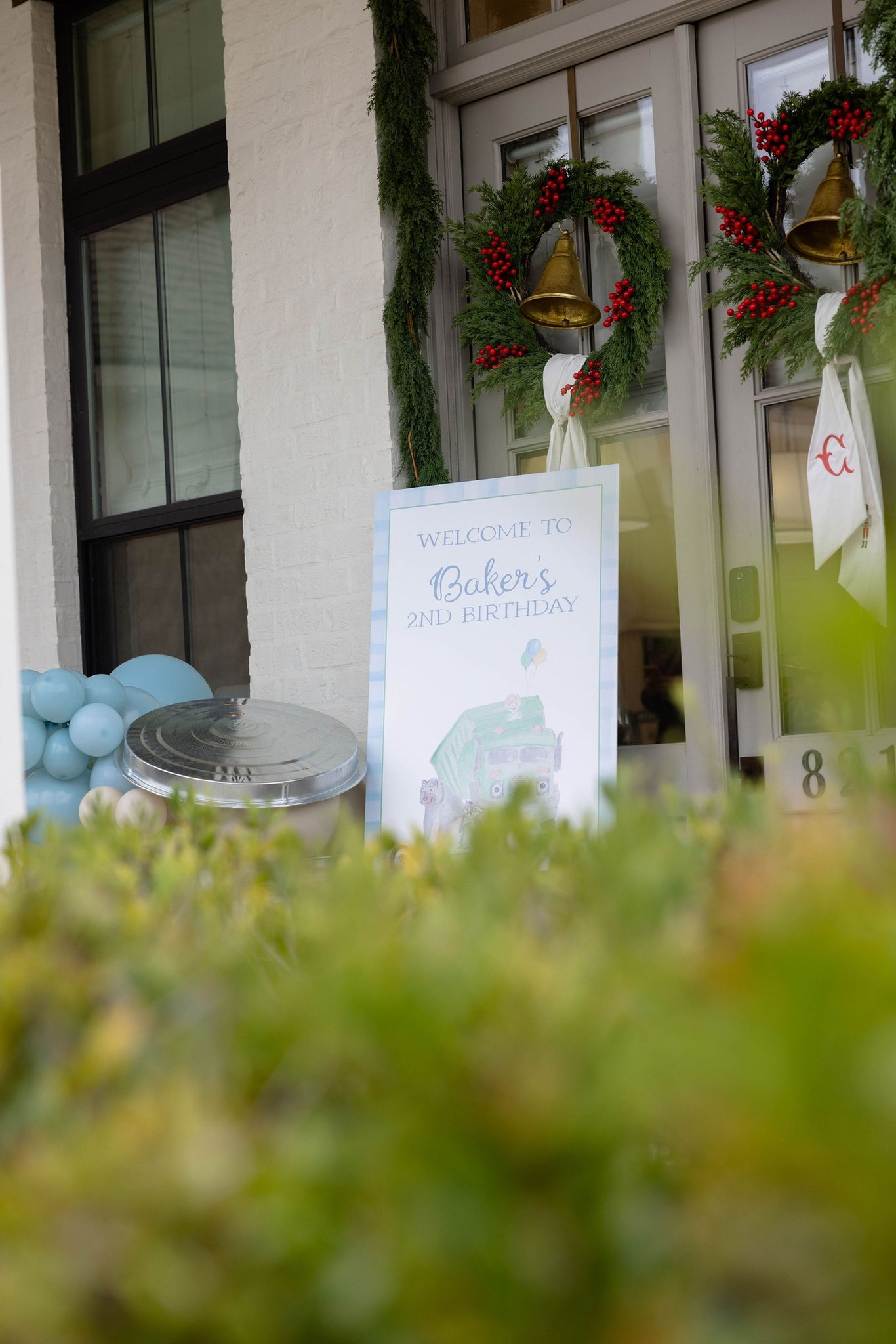 Welcome to Baker's 2nd Birthday party sign outside a home entrance with festive holiday decor