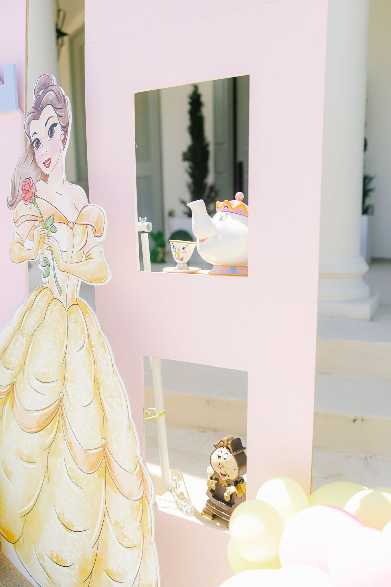 Life-sized Belle cutout standing next to a display featuring Mrs. Potts, Chip, and Cogsworth ornaments.