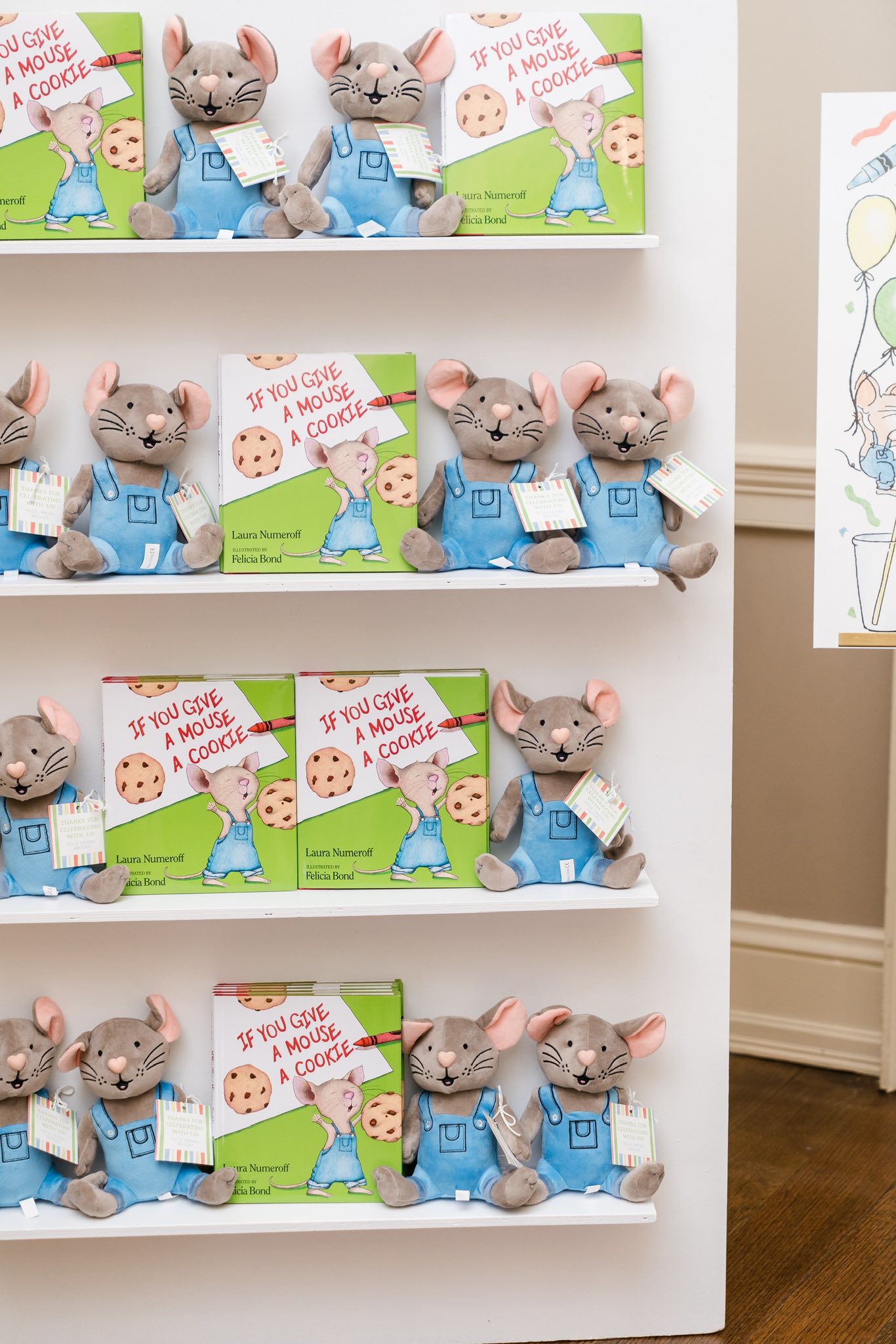Shelves stocked with If You Give a Mouse a Cookie books and matching mouse plush toys in blue overalls.