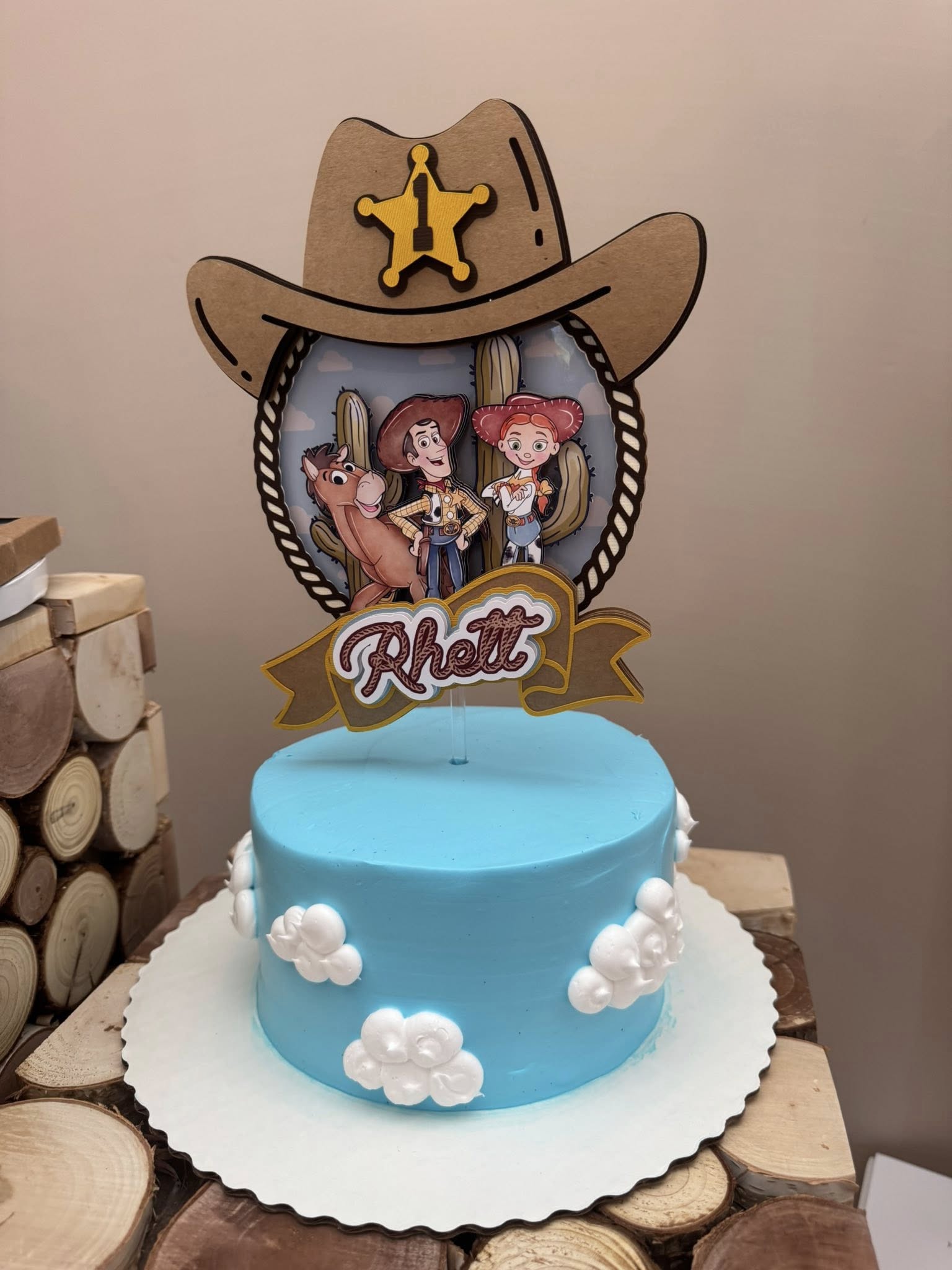 Personalized Toy Story cake topper featuring Woody, Jessie, and Bullseye with a cowboy hat and the name Rhett.
