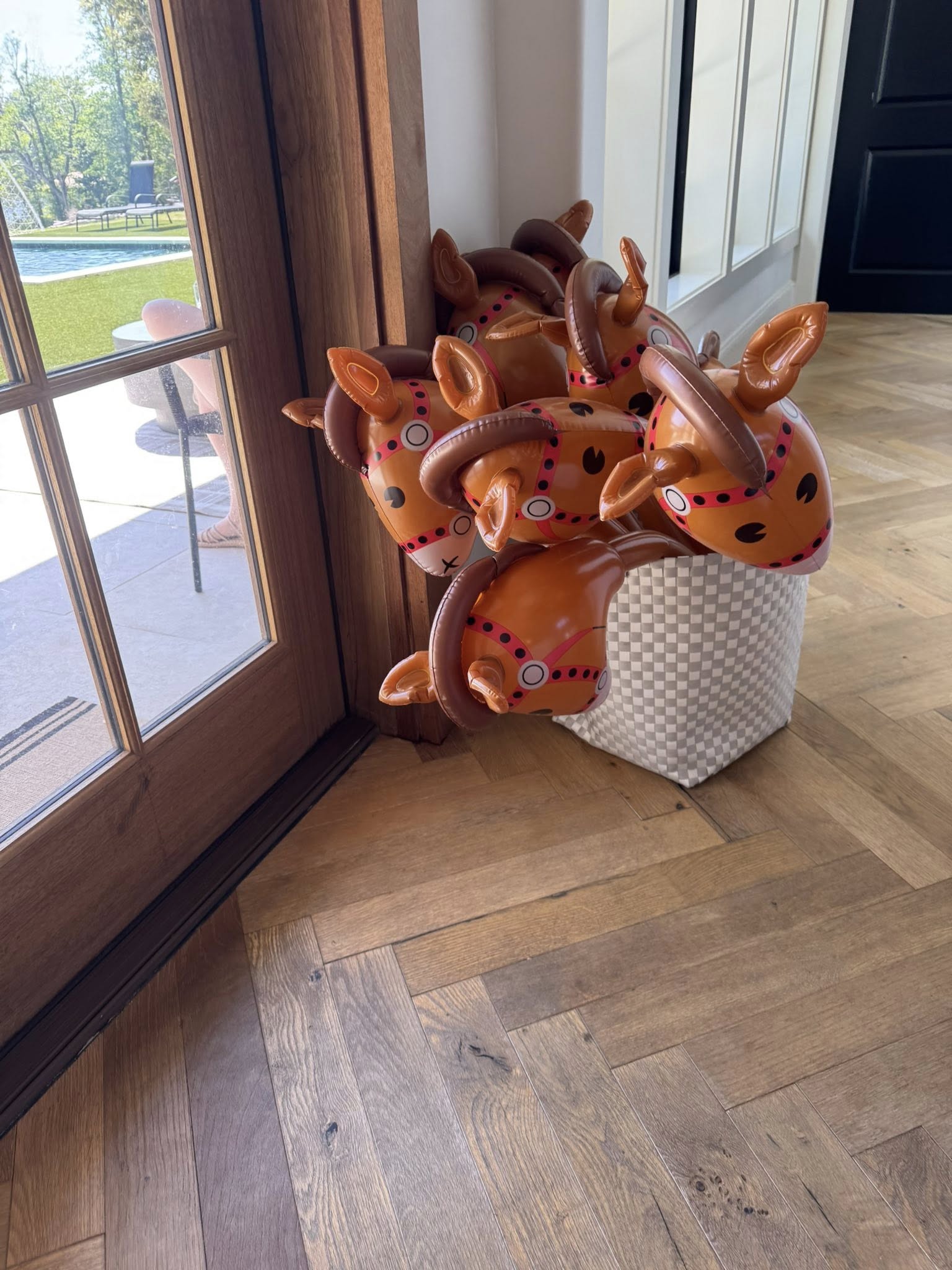 Inflatable hobby horse toys in a patterned storage basket indoors