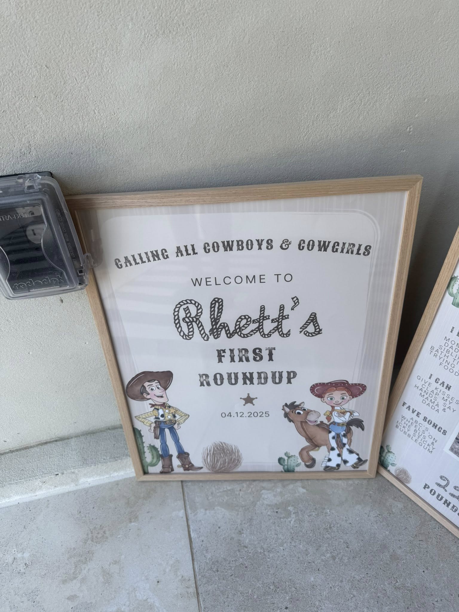 Toy Story-themed welcome sign for Rhett's first birthday party with illustrations of Woody, Jessie, and Bullseye.