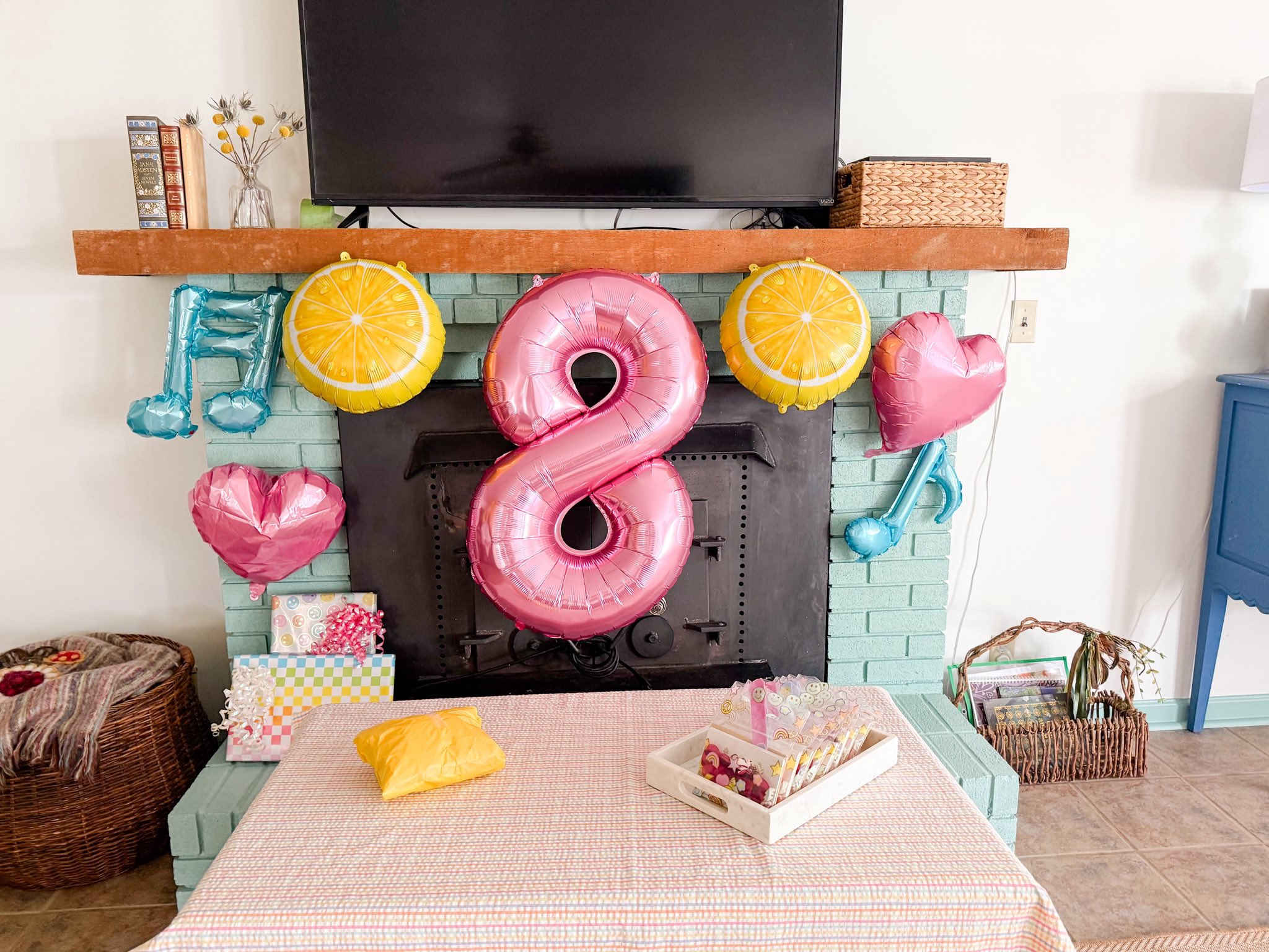 Birthday fireplace setup with number 8 balloon, lemon and music note balloons, and small gifts.