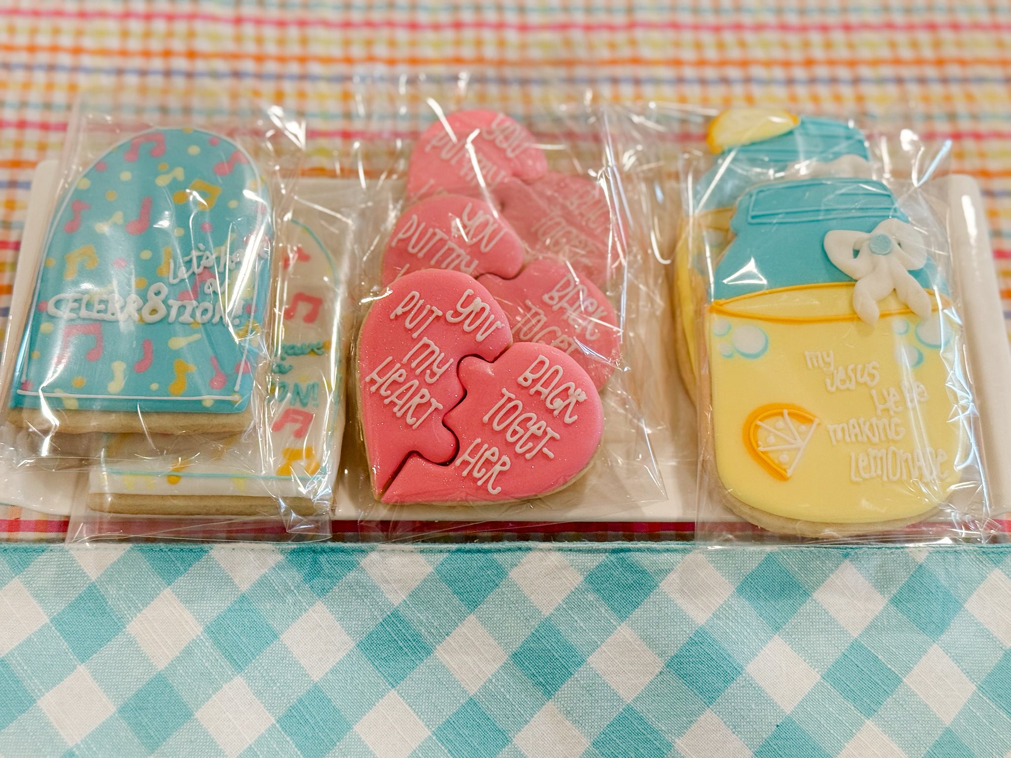 Decorated sugar cookies including music-themed cookies, heart puzzle pieces, and lemon mason jar designs.