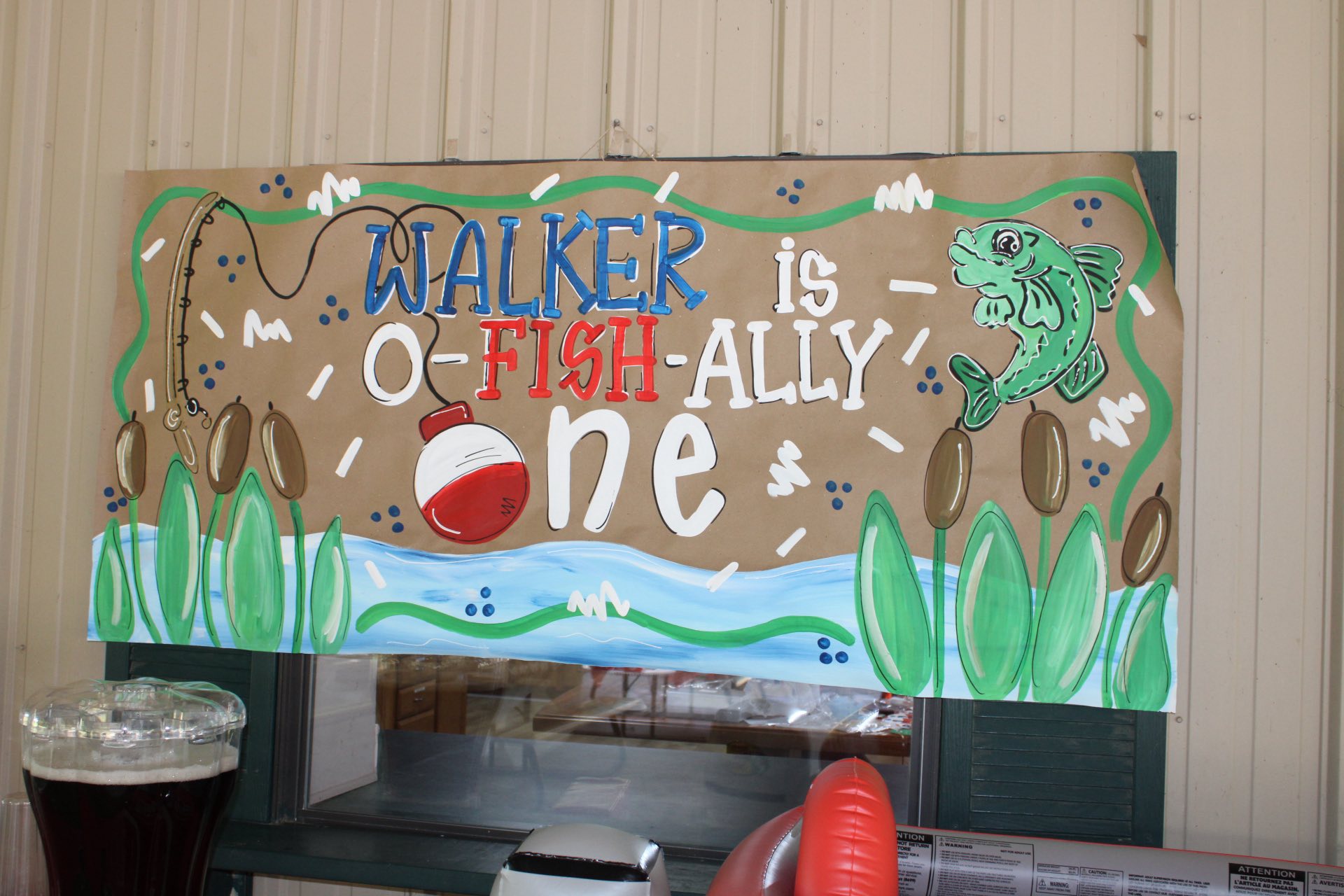 Handmade brown paper party banner with a fishing theme that reads Walker is O-Fish-Ally One.