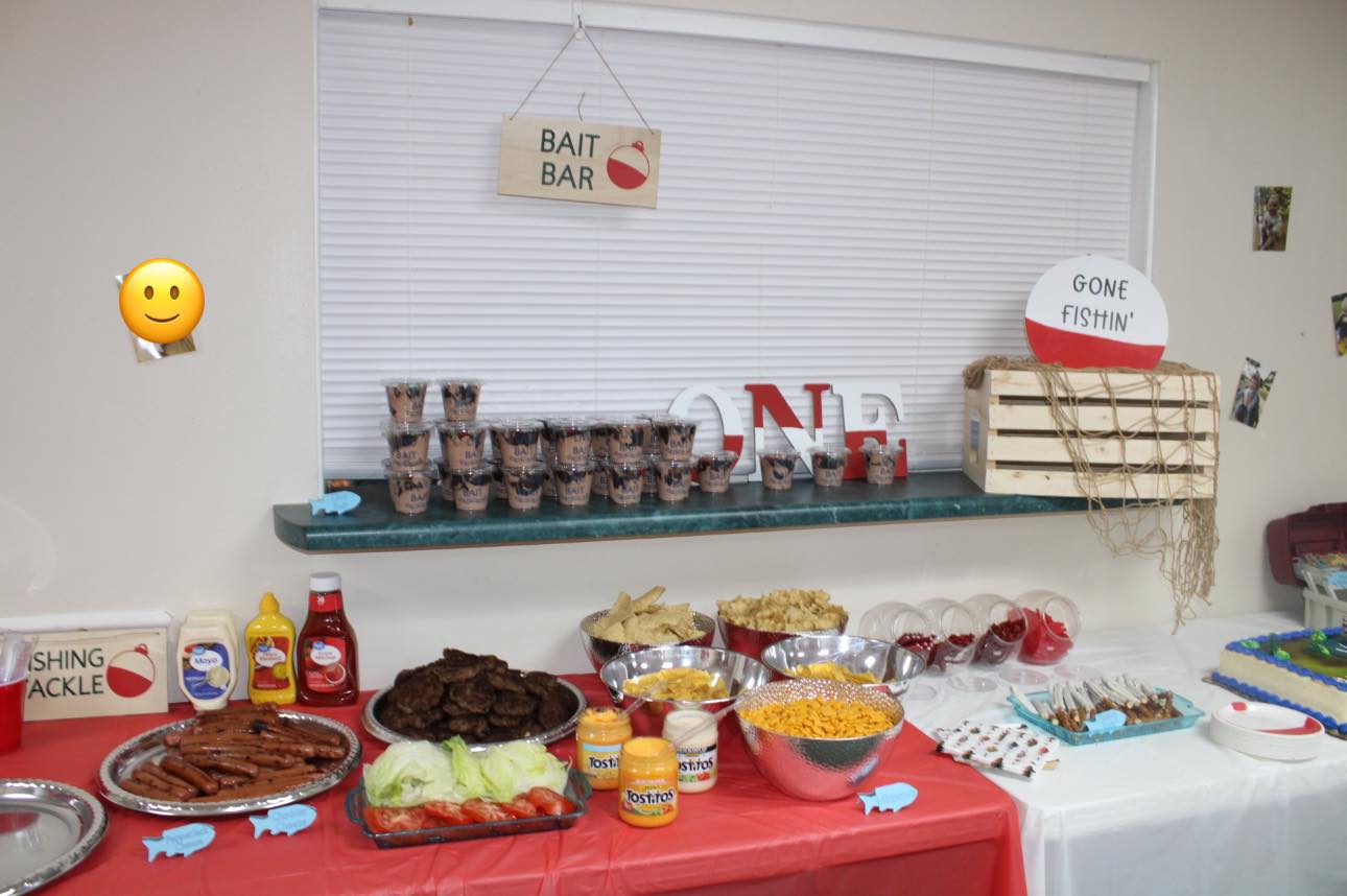 Fishing-themed party food table with a Bait Bar sign and decorations.