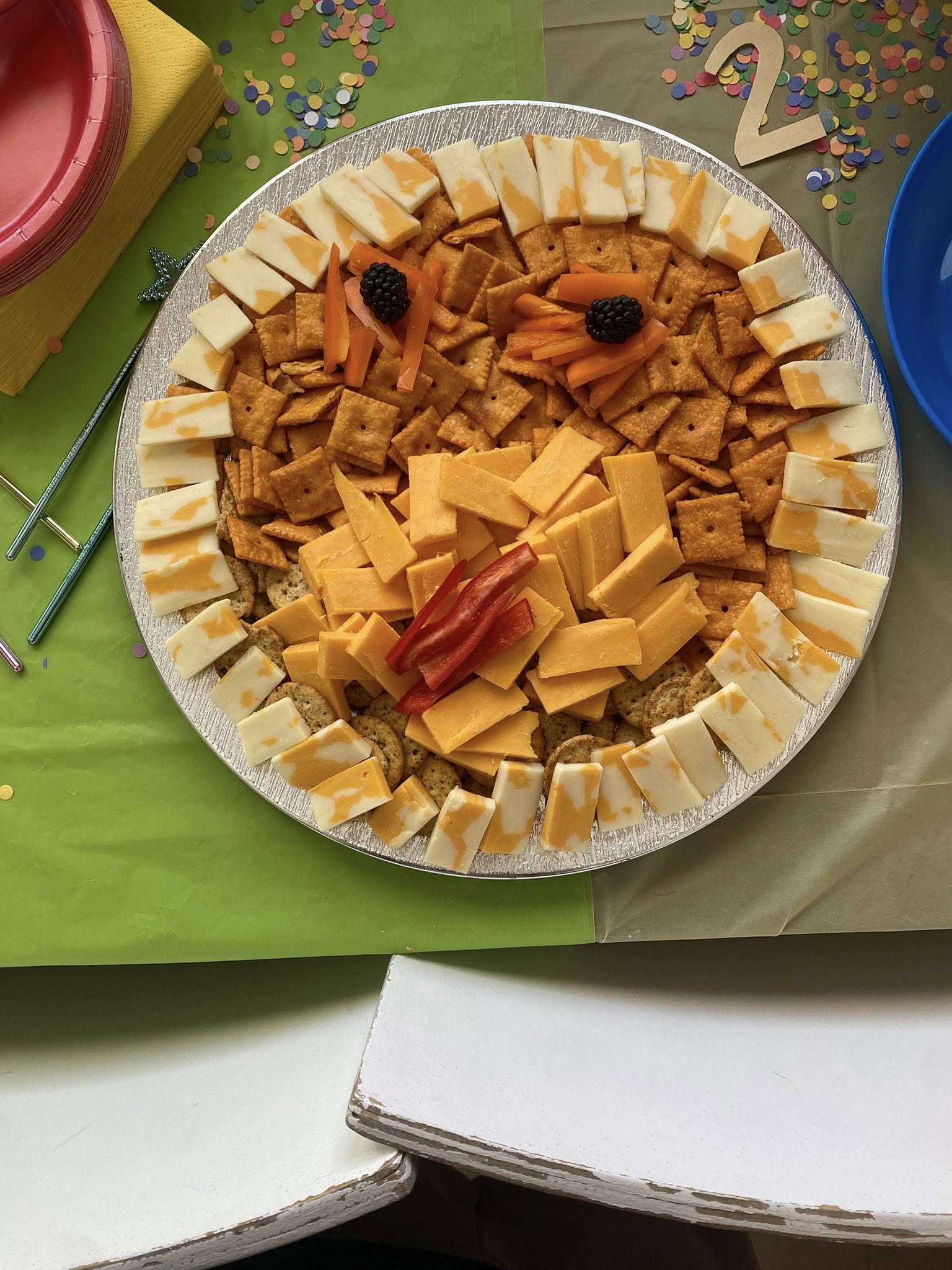 Round party platter arranged as a lion face with cracker eyes, blackberry pupils, and cheddar cheese features.