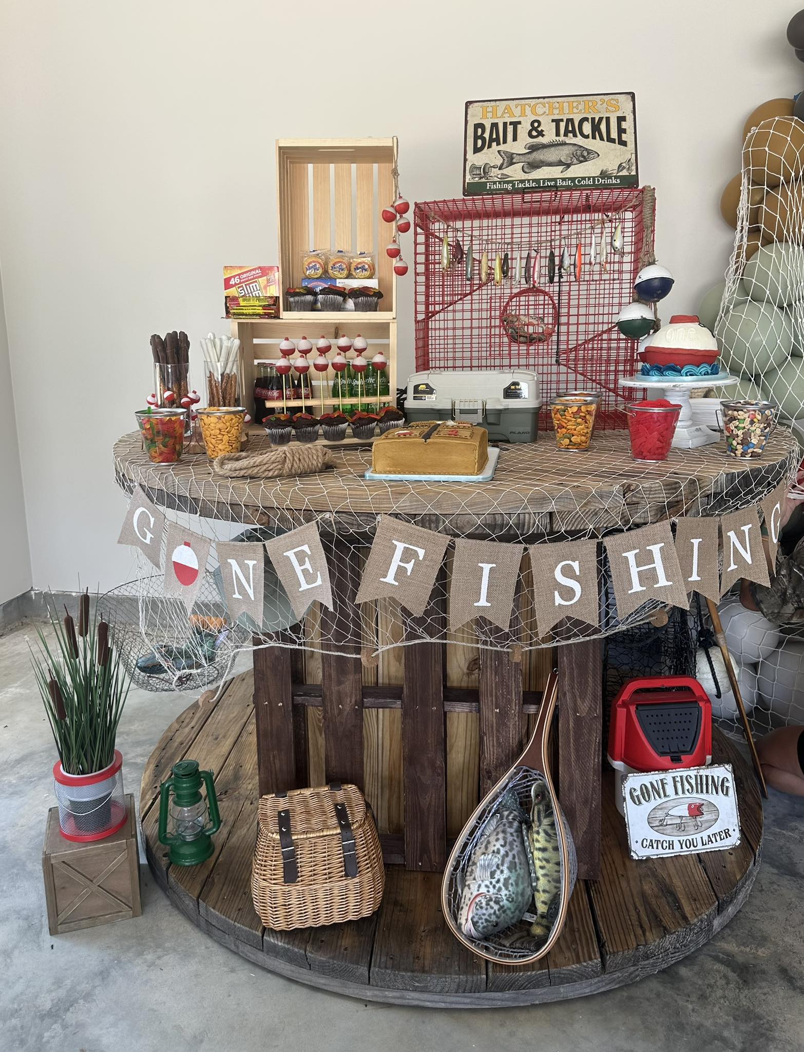 Table decorated with a Gone Fishing theme for a first birthday party including themed snacks and decor.