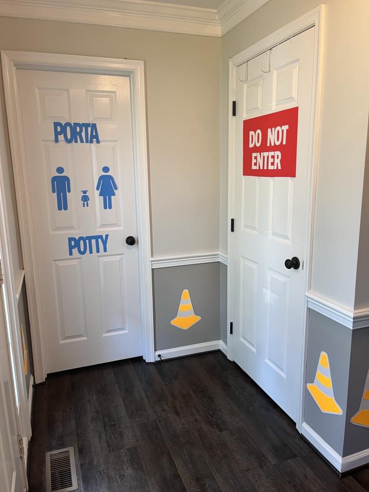 Two interior doors with construction-themed signs, one marked as Porta Potty and the other as Do Not Enter.