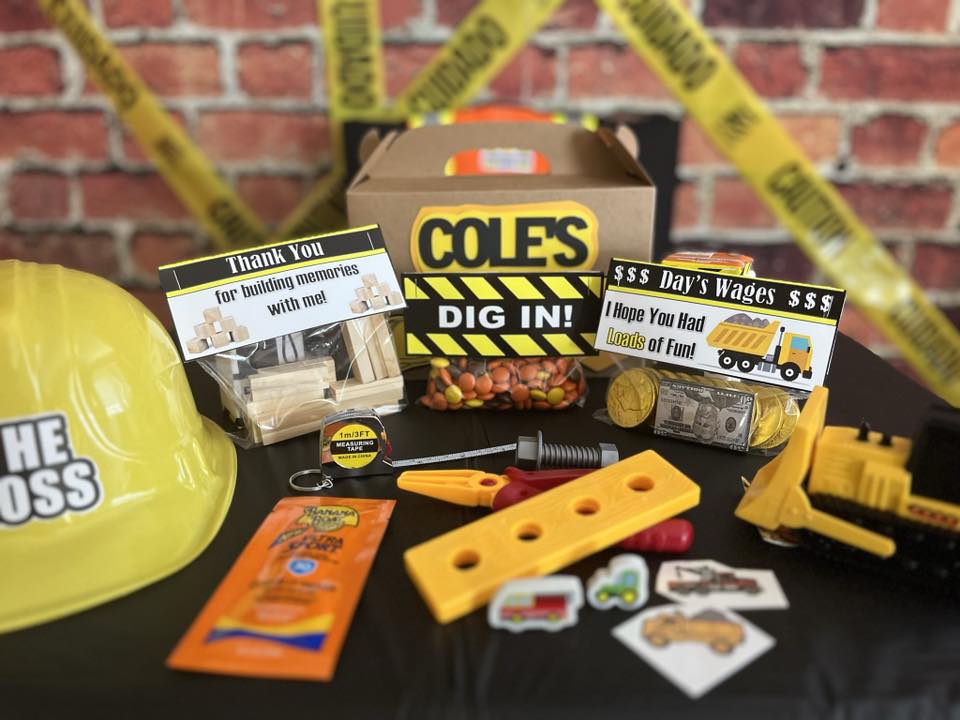 Cole's construction themed party favor box with tools, candy, toy truck, and a yellow hard hat.