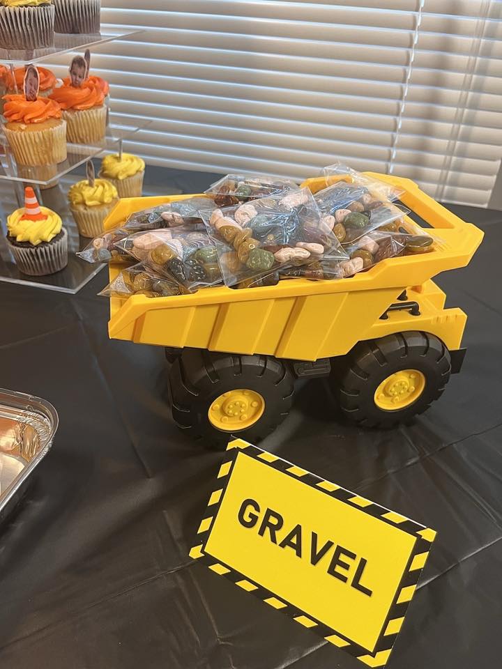 Toy dump truck filled with bags of chocolate rock candy labeled with a Gravel sign