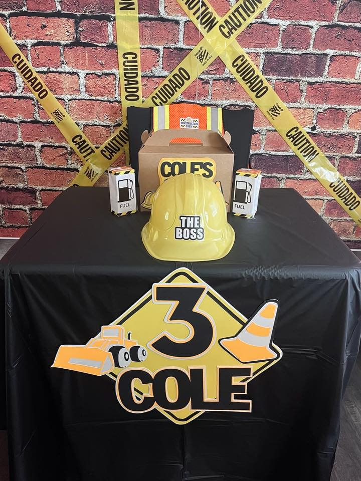 Construction-themed birthday party decorations featuring a yellow hard hat labeled The Boss and a sign for Cole's 3rd birthday.