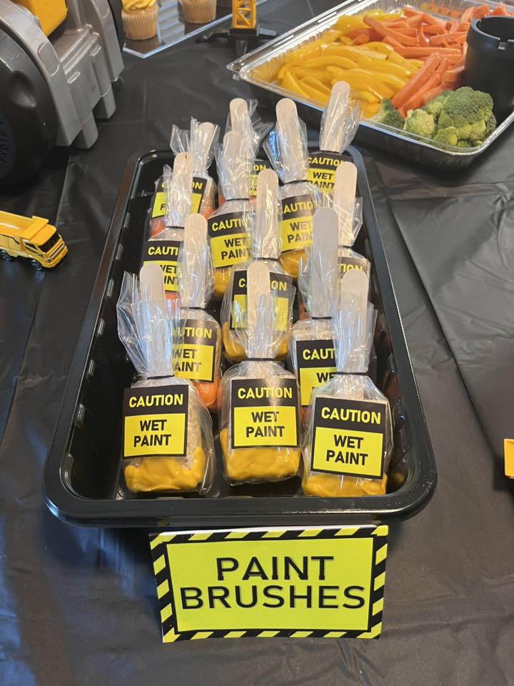 Individually wrapped paint brushes labeled Caution Wet Paint in a serving tray next to vegetable snacks.