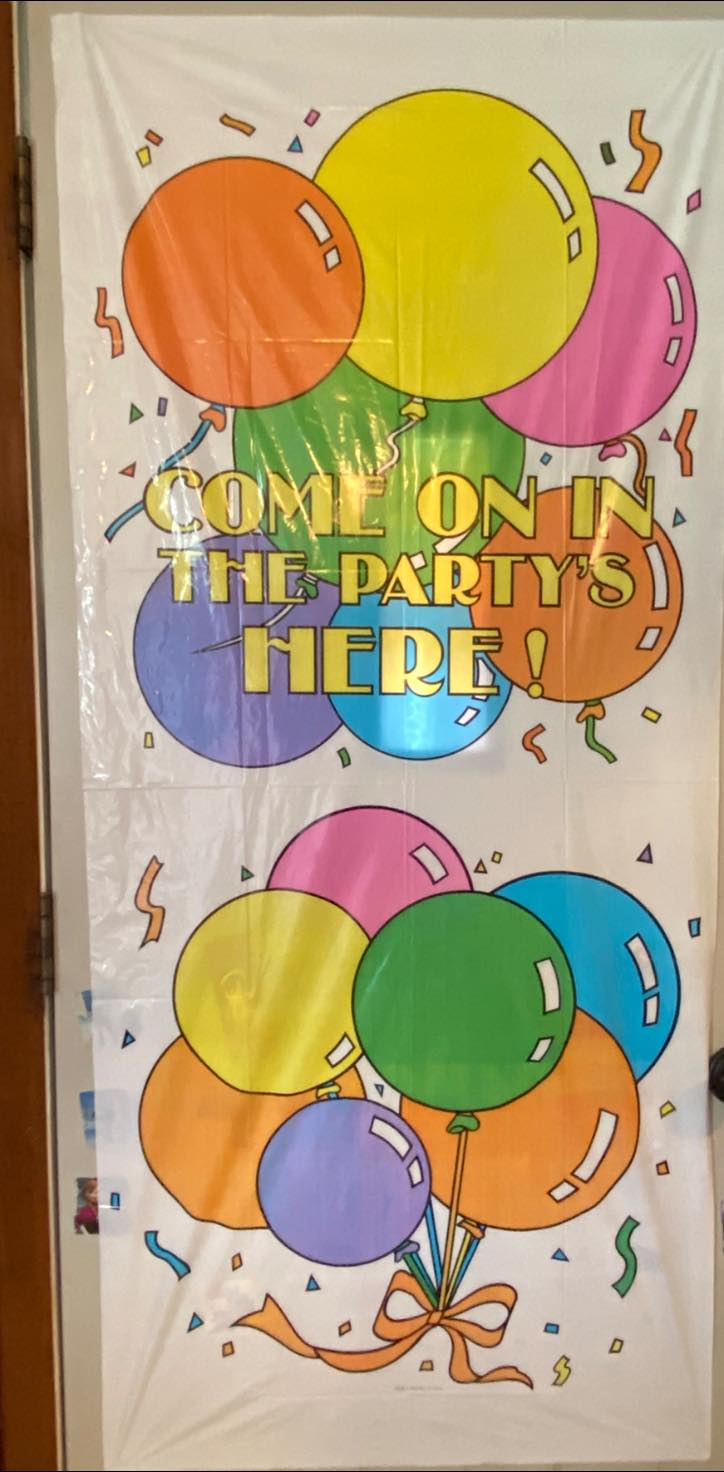 Colorful party door banner decorated with balloons and reading Come on in the party's here