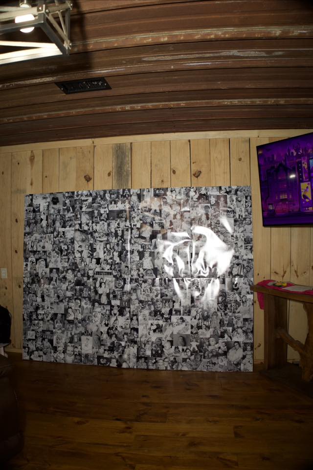 Large black and white photo collage mounted on a wood paneled wall.