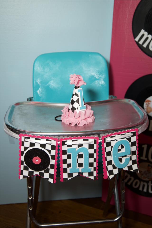 First birthday high chair decoration set with checkered pattern, pink frills, and record motif.
