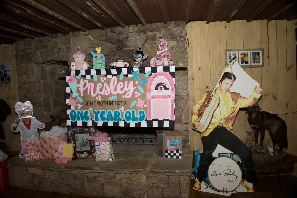 First birthday party decorations with a rock-and-roll Elvis theme featuring a personalized Presley sign.