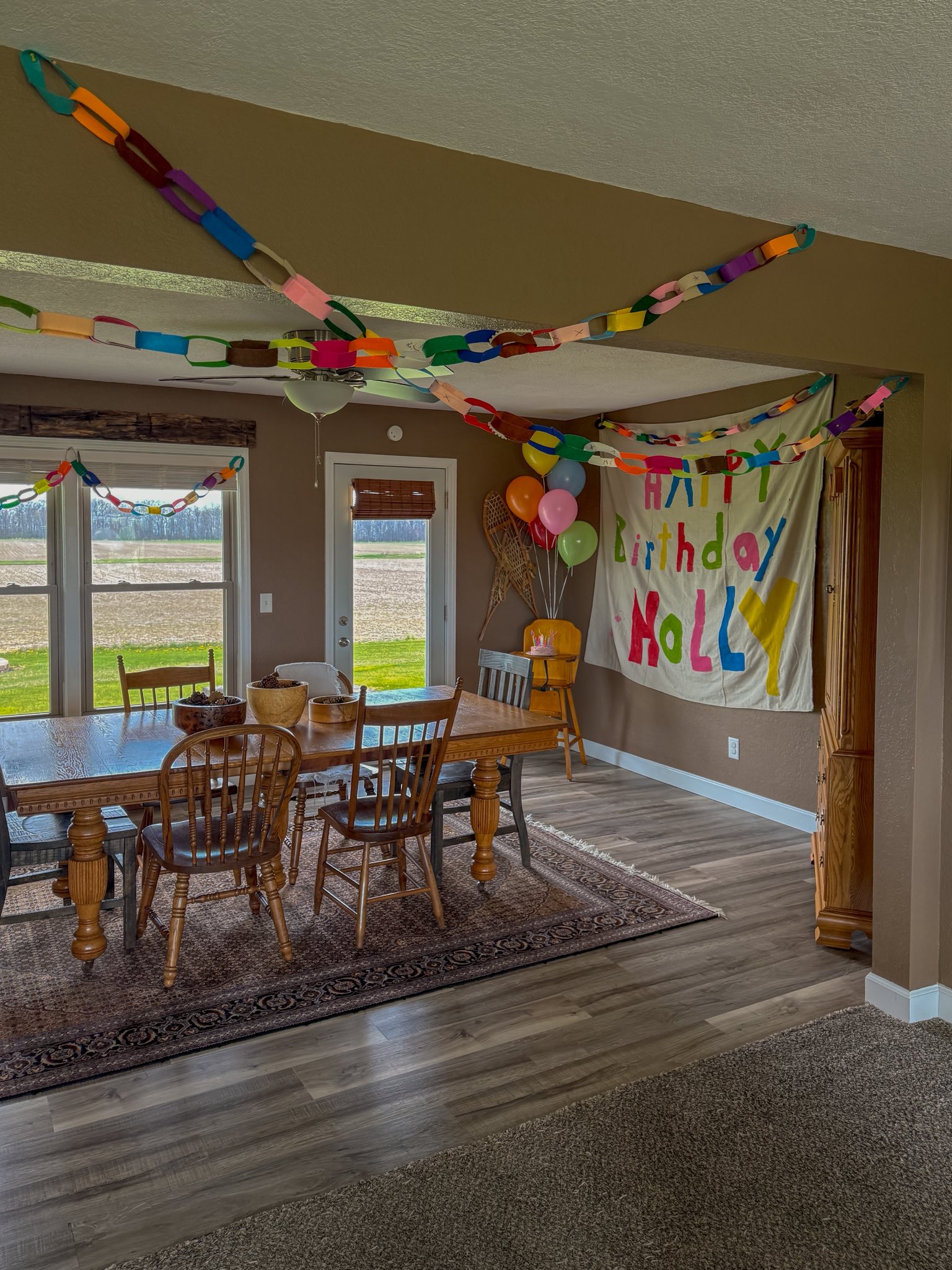 Dining room decorated for a birthday with paper chain streamers and a Happy Birthday Molly banner.