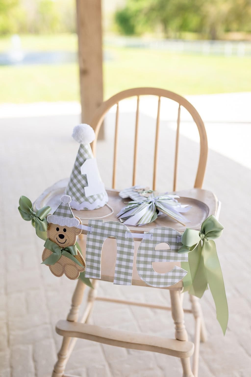 Sage green gingham high chair banner with matching birthday hat for a first birthday