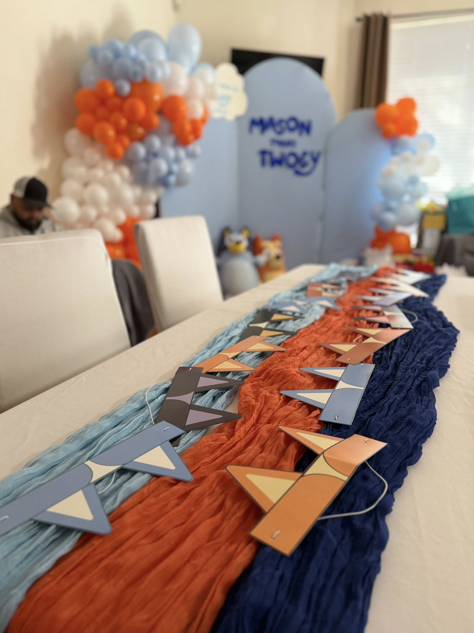 Blue and orange birthday party table decor with themed garland and streamers