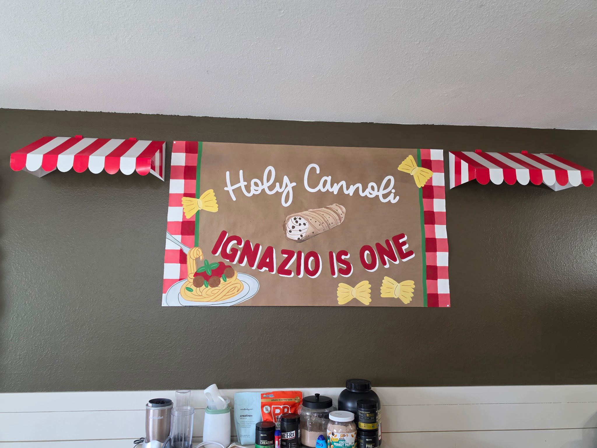 Holy Cannoli Ignazio is One Italian-themed birthday banner with cannoli, pasta, and red gingham decorations.