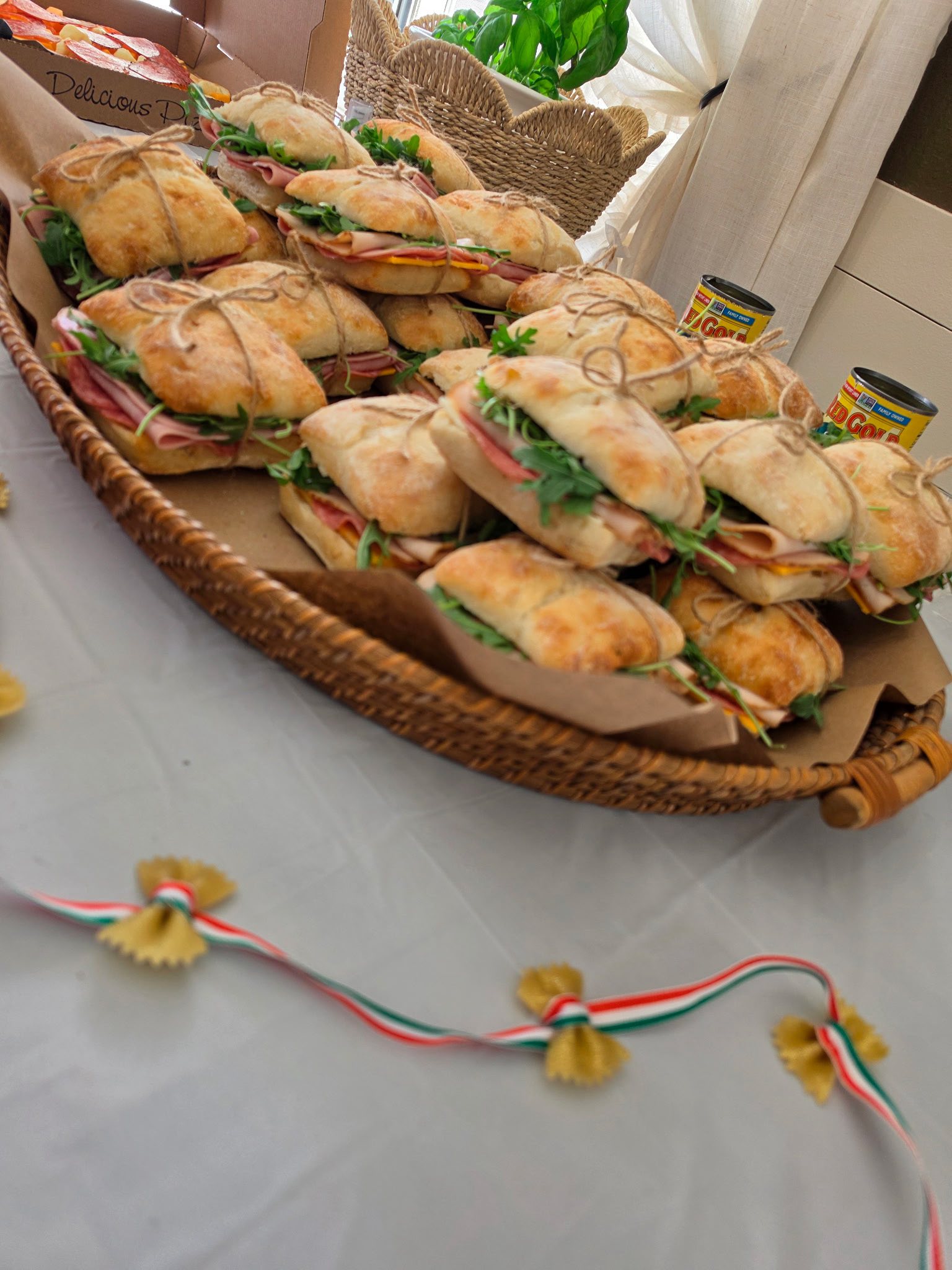Platter of small sandwiches tied with twine, served on a wicker tray.
