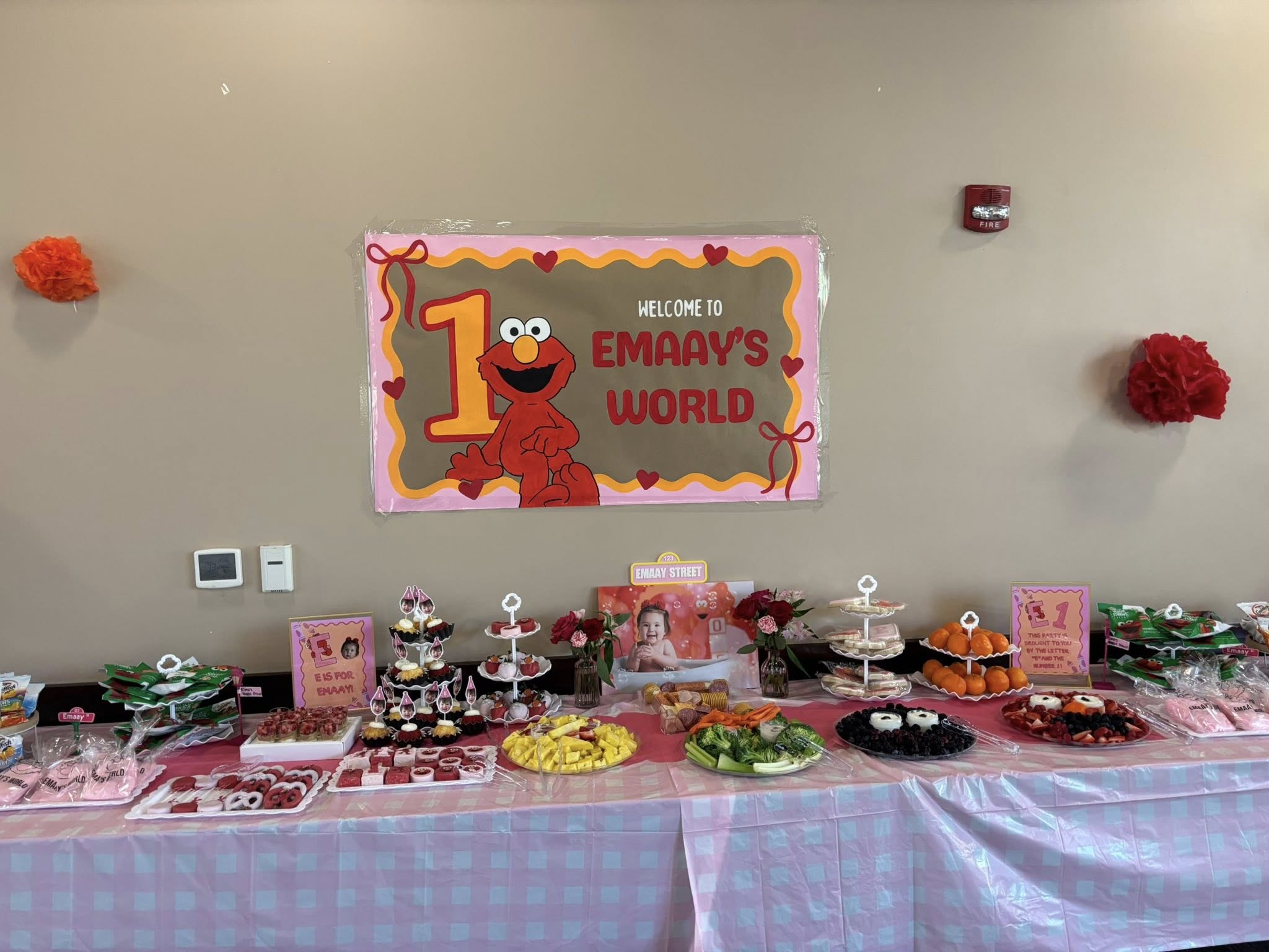 Elmo-themed first birthday party decorations and dessert table display.