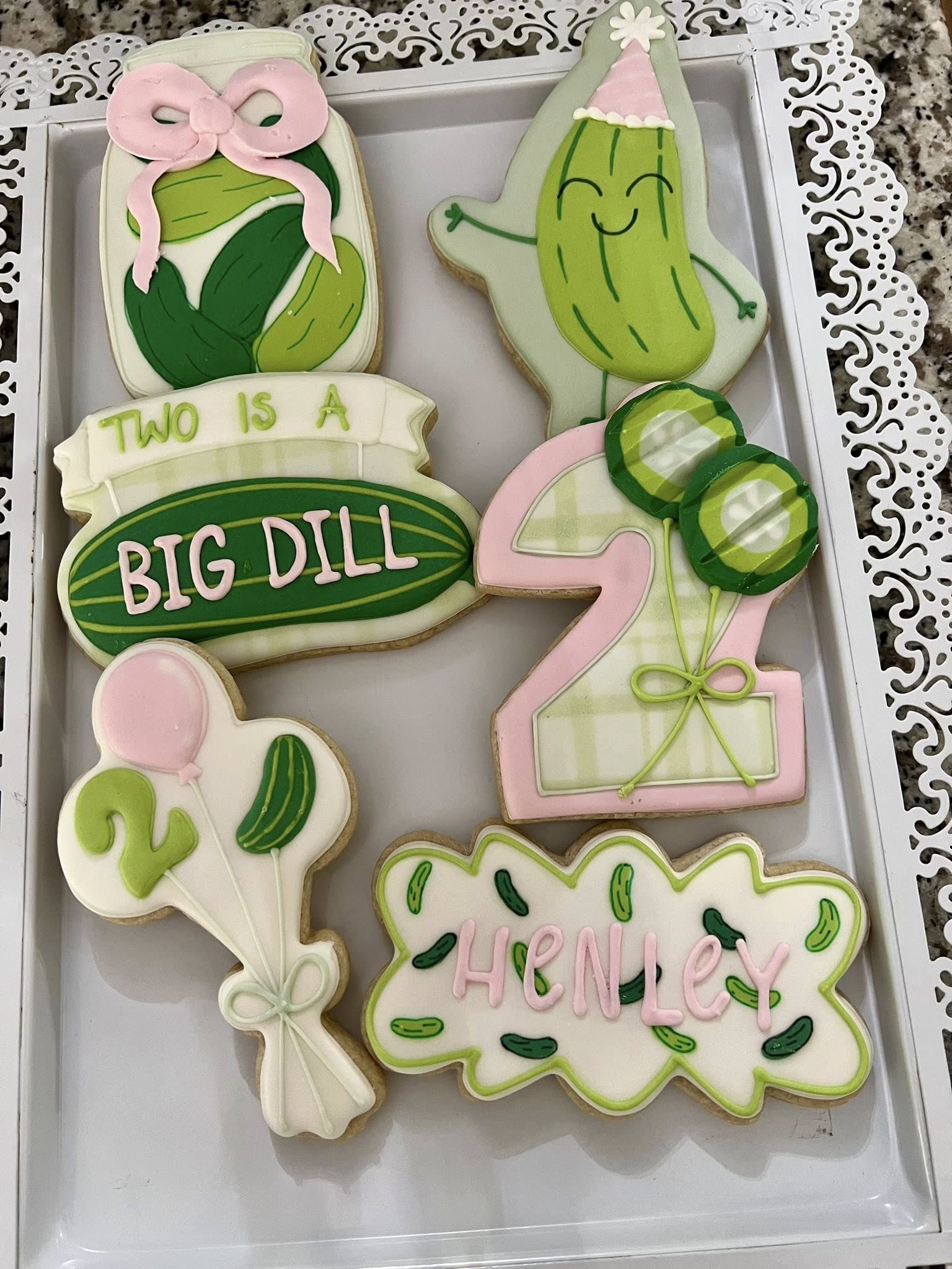 Custom pickle-themed sugar cookies for a second birthday party, featuring the name Henley and pickle designs.