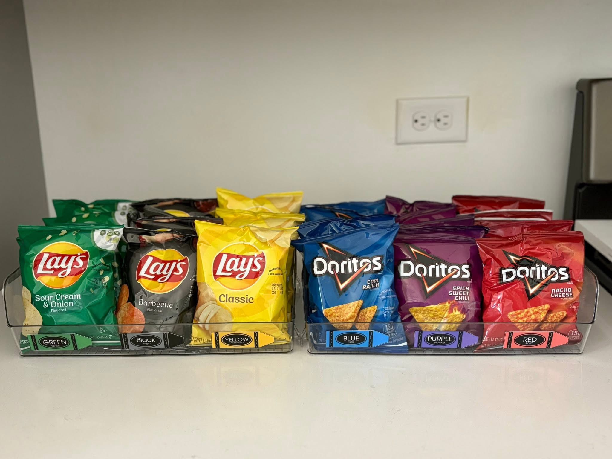 Assorted single-serve bags of Lay's and Doritos potato and tortilla chips organized in clear plastic containers.