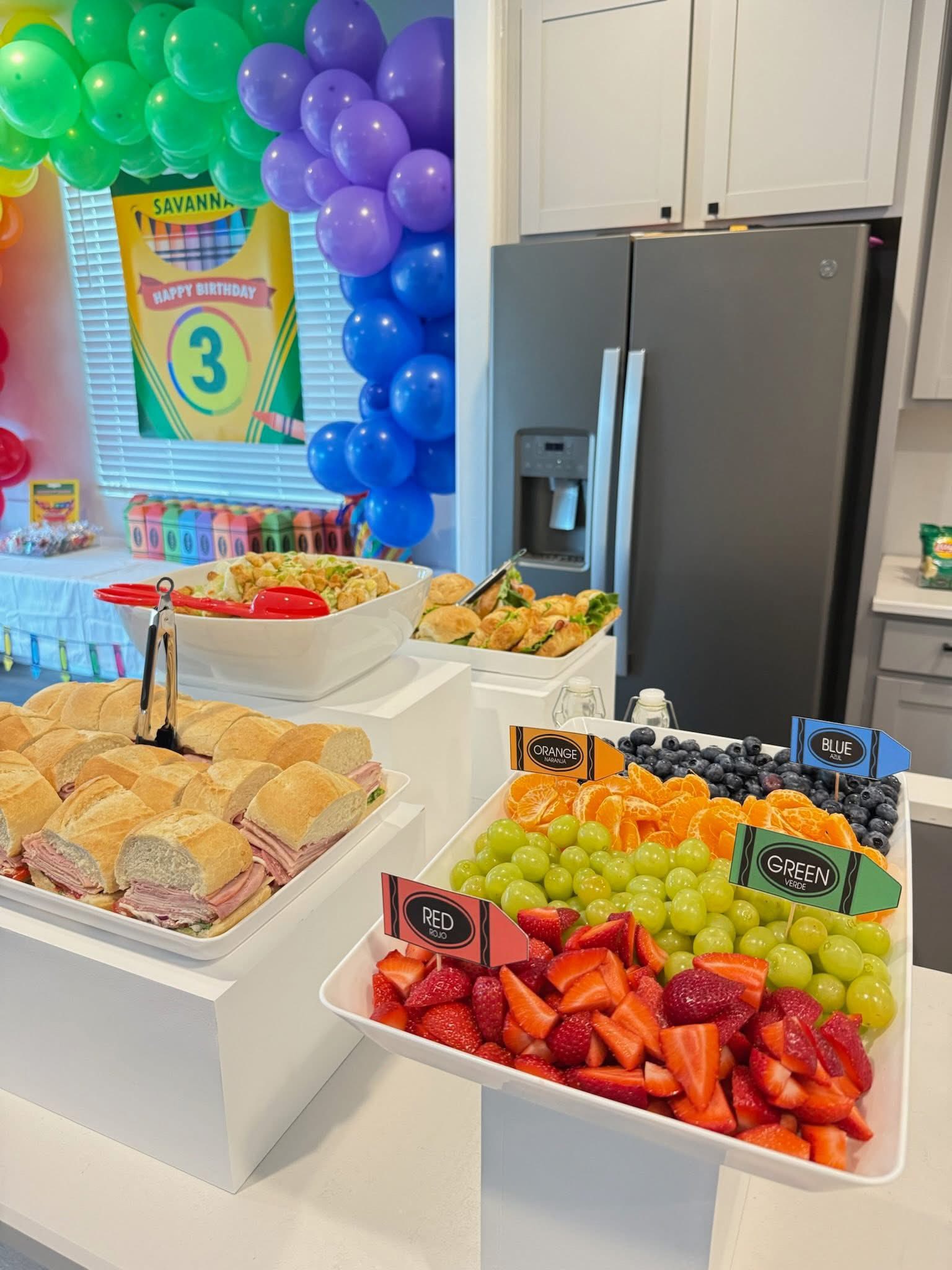 Fruit tray with color-coded crayon labels served at a child's crayon-themed birthday party.
