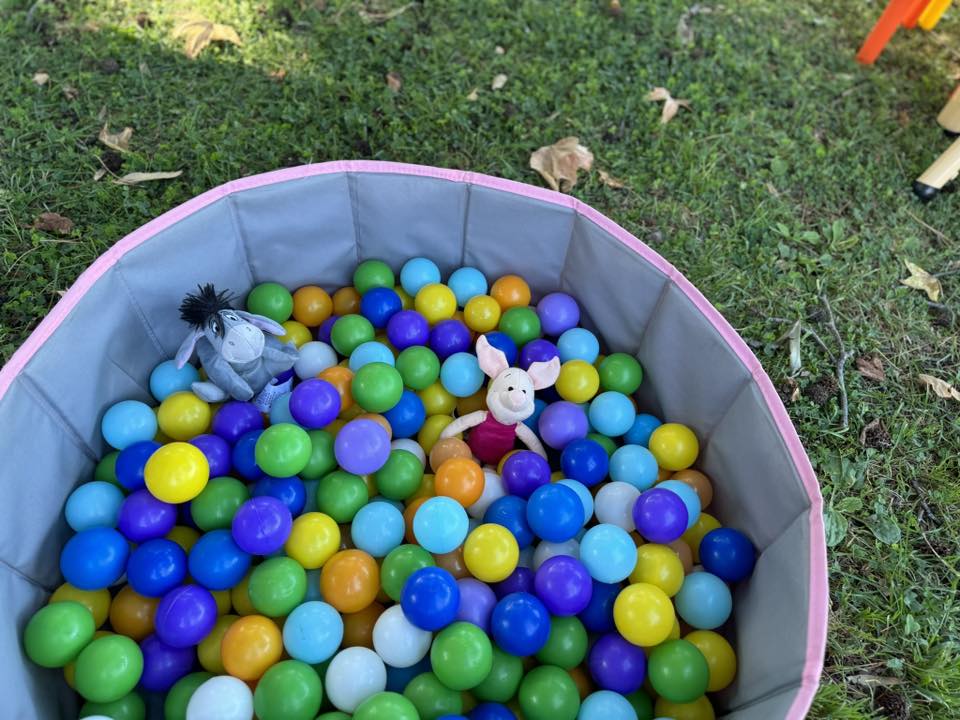 Foldable circular ball pit filled with colorful plastic balls, Eeyore and Piglet plush toys sitting inside.